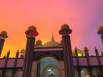 Low angle view of illuminated building against sky during sunset