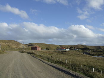 Road amidst field against sky