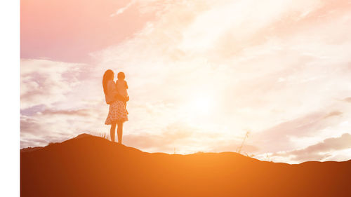 Silhouette man standing on mountain against sky during sunset