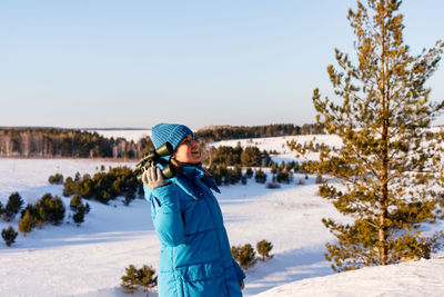 Full length of woman standing on snow covered field