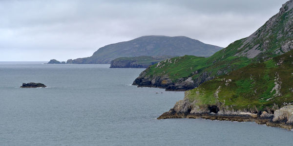 Scenic view of sea and mountains against sky