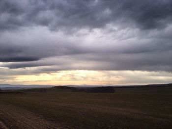 Scenic view of field against cloudy sky