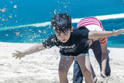 Rear view of boys playing on beach