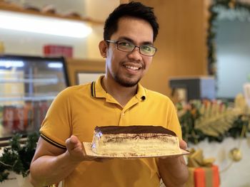 Portrait of smiling man holding ice cream cake