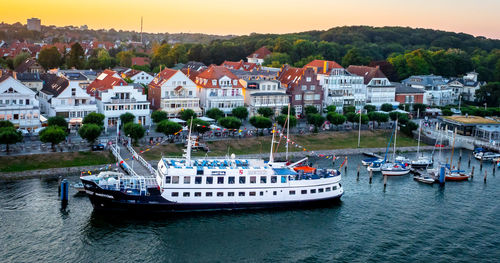 Boats moored in river by town