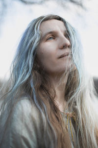 Close up beautiful woman with long gray brown hair looking up portrait picture