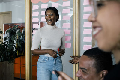 Female business professional laughing during meeting with colleagues at office