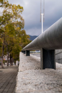 Close-up of railings on footpath against sky