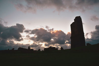 Low angle view of silhouette building against sky during sunset