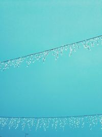 Low angle view of water drops against blue sky