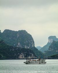 Boat in sea against mountains