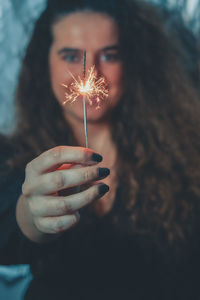 Midsection of woman holding sparkler