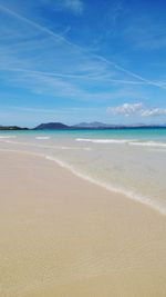 Scenic view of beach against blue sky