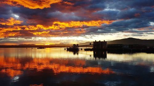 Scenic view of sea against dramatic sky during sunset