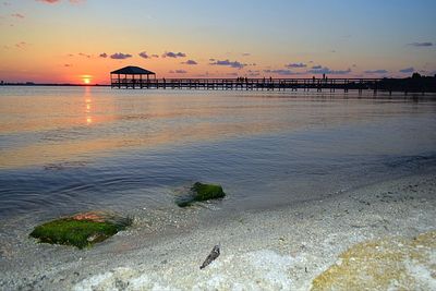 Pier on sea at sunset