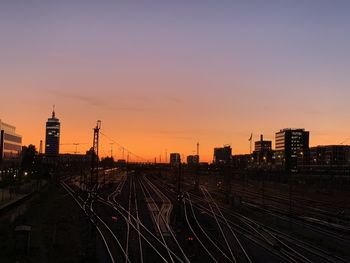 High angle view of railroad tracks by buildings against sky during sunset from hackerbridge munich