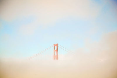 Low angle view of suspension bridge against sky