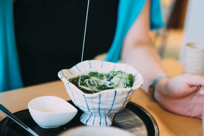 Midsection of person having food on table