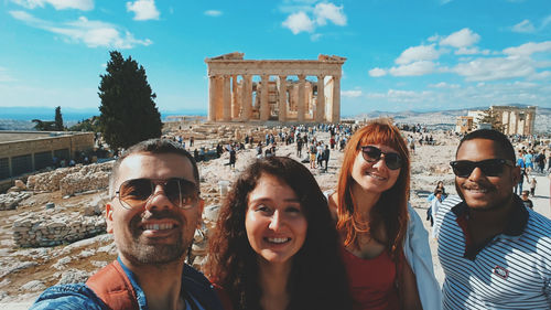 Portrait of smiling friends against ancient structure