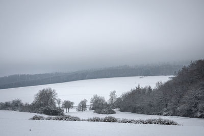 Scenic view of snow covered field against sky