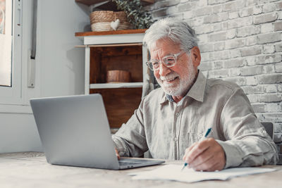 Senior man using laptop while sitting at home