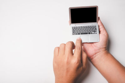 Midsection of person holding smart phone against white background