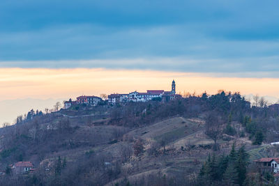 Buildings in city against sky during sunset