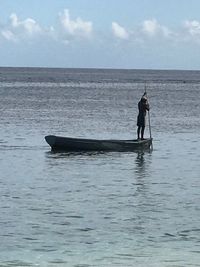 Man standing in sea against sky