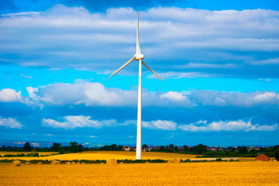 Scenic view of field against cloudy sky