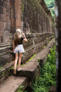 Rear view of woman walking on footpath
