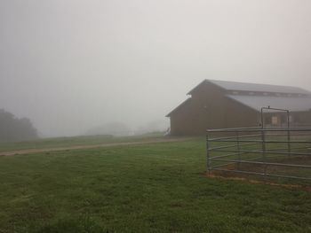 Built structure on grassy field during foggy weather