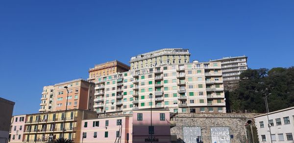 Low angle view of buildings against clear blue sky