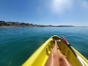 Low section of person on sea against sky