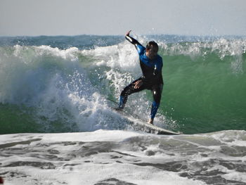 Full length of man surfboarding in sea