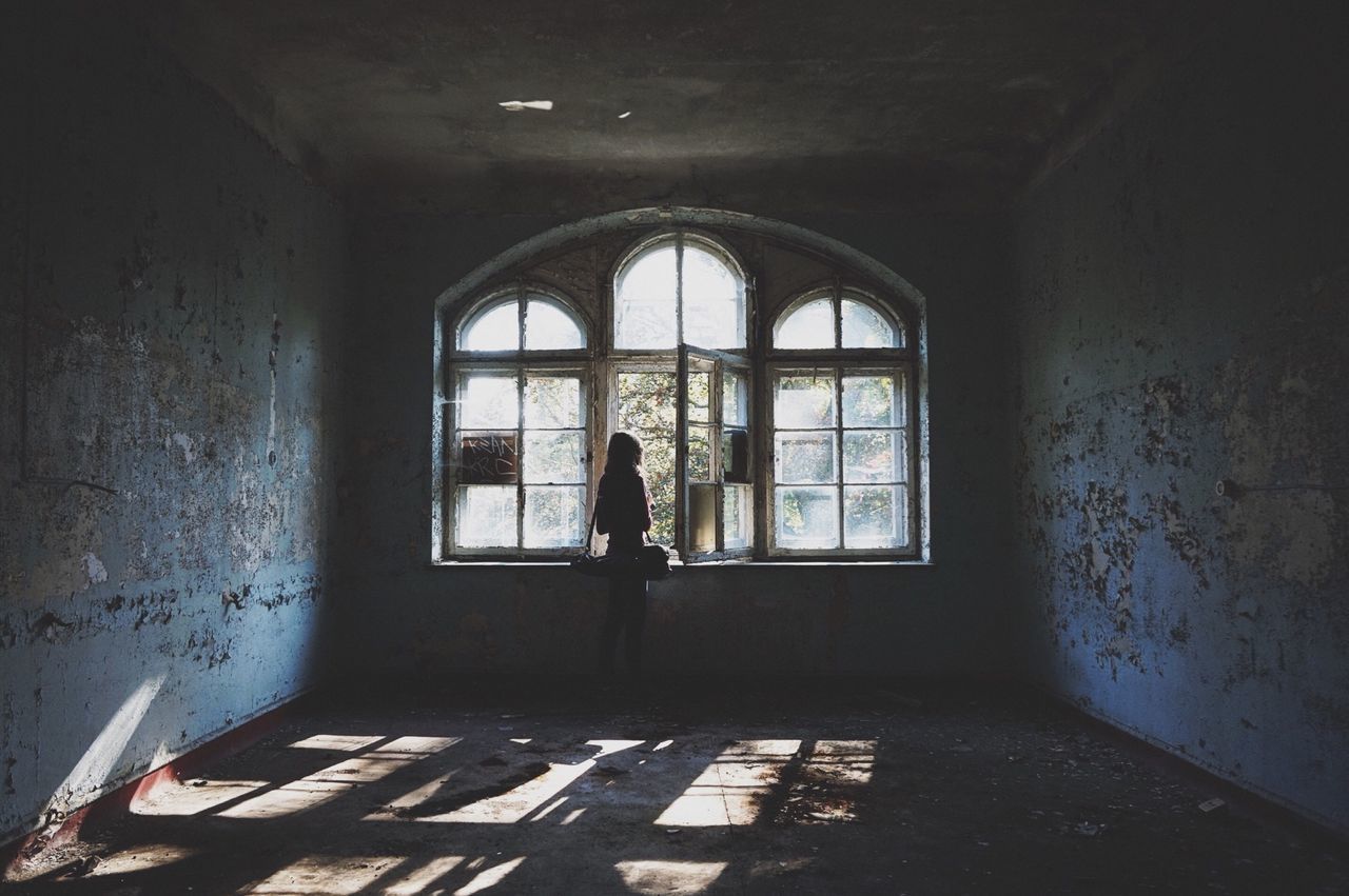 indoors, lifestyles, full length, window, leisure activity, architecture, standing, arch, built structure, men, wall - building feature, casual clothing, rear view, person, silhouette, door, day, walking