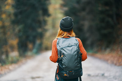 Rear view of woman walking on road