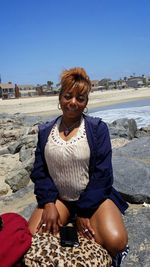 Portrait of woman crouching at beach