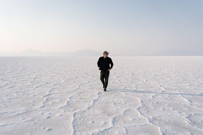 Rear view of man standing on snow covered landscape