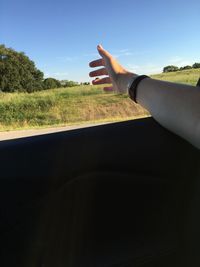 Close-up of hand against sky