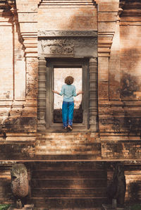 Rear view of mid adult woman standing in historic building