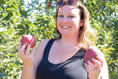 Portrait of smiling woman holding apple