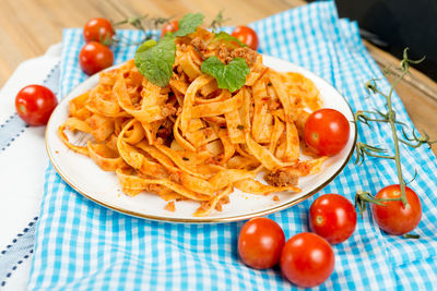 Close-up of fresh spaghetti served in plate and ketchup on paper
