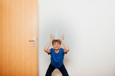 Full length of boy standing against wall