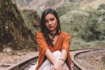 Portrait of beautiful young woman with railroad tracks