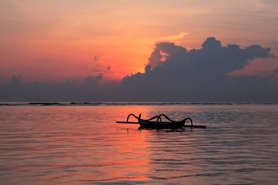 Silhouette boat in sea against sky during sunset