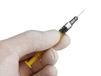 Close-up of hand holding pen against white background