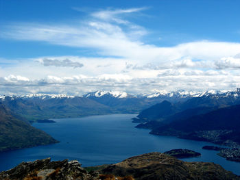 Scenic view of sea and snowcapped mountains against sky