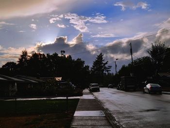 Cars on street amidst buildings in city against sky