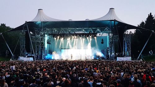 Crowd at music concert against sky