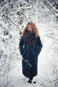 Portrait of young woman standing in snow